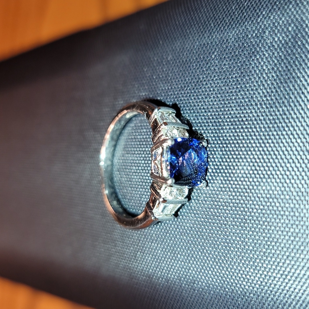 Sterling silver blue cortanite size 7. Two clear round and two baguette on sides